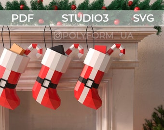 May include: Three red and white Christmas stockings with candy canes hanging from a white fireplace mantel. The stockings are filled with gifts. The text "STUDIO3" is visible above the fireplace.