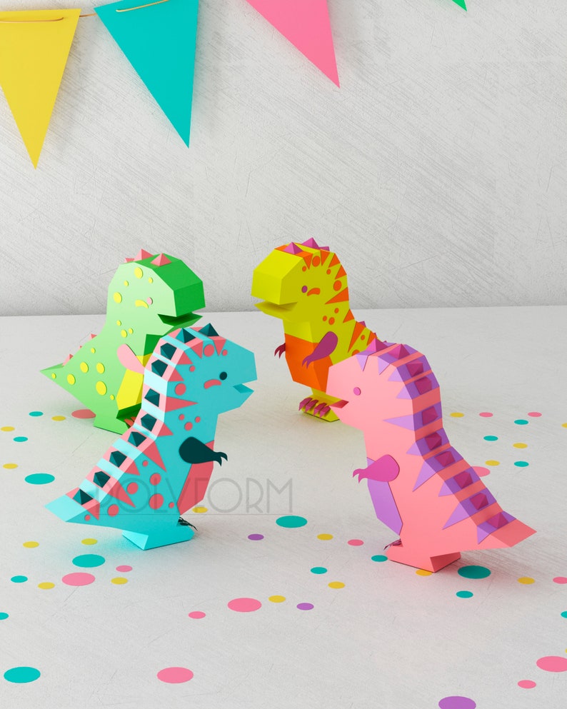 May include: Four papercraft dinosaurs in different colors: green, blue, yellow, and pink. The dinosaurs are standing on a white surface with colorful confetti.