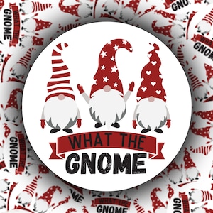 May include: Three gnomes with red, white, and blue hats stand in front of a red banner with the text "What the Gnome".