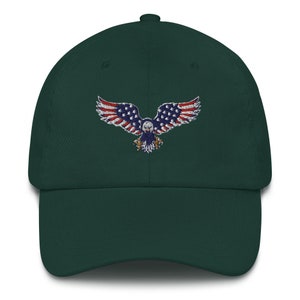 May include: A dark green baseball cap with an embroidered eagle design. The eagle's wings are decorated with the stars and stripes of the American flag. The cap has a curved peak and an adjustable fabric strap.