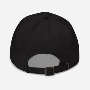 Puede incluir: Gorra de b&eacute;isbol negra con visera curva y cierre de hebilla met&aacute;lica ajustable. La gorra tiene un dise&ntilde;o de seis paneles con un bot&oacute;n en la parte superior. La parte trasera de la gorra tiene una abertura para ventilaci&oacute;n.