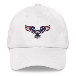 May include: White baseball cap with an embroidered eagle design, incorporating the American flag. The eagle's wings are red and white striped, with a blue body and stars. A classic, adjustable hat.
