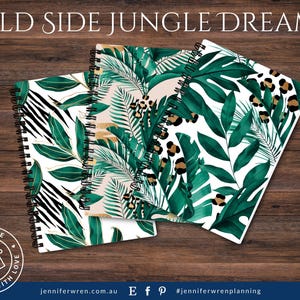May include: Three spiral bound notebooks with different tropical leaf designs. The covers feature green leaves, gold accents, and black and white zebra stripes. The notebooks are on a wooden surface.