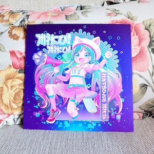 Op de afbeelding: Vierkante print met een kleurrijk anime-achtig personage met lang roze haar, een kattenorenhoed en een megafoon. De achtergrond is een levendig paars met Japanse tekst.