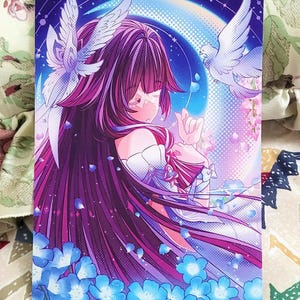 K&ouml;nnte beinhalten: Ein rechteckiger Kunstdruck mit einer Anime-Figur mit langem magentafarbenem Haar in einem wei&szlig;en Gewand. Die Figur ist umgeben von zwei wei&szlig;en Tauben, blauen Blumen und einem gro&szlig;en, blau-violetten Hintergrund mit einer Mondsichel.