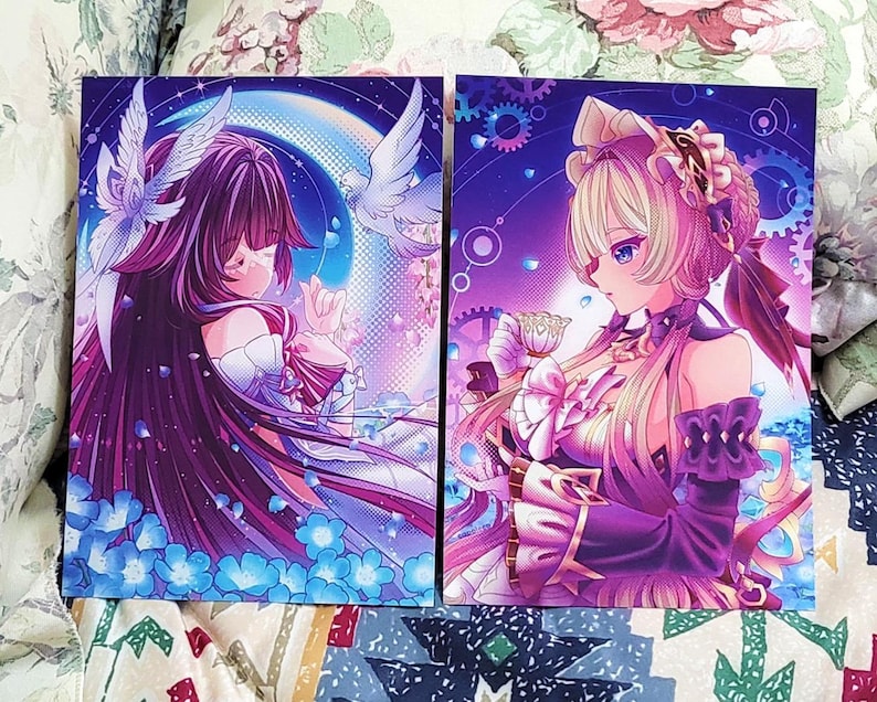 K&ouml;nnte beinhalten: Zwei rechteckige Kunstdrucke mit Charakteren im Anime-Stil. Der linke Druck zeigt eine Figur mit langem dunklen Haar, wei&szlig;en Fl&uuml;geln und blauen Blumen. Der rechte Druck zeigt eine blonde Figur in einem R&uuml;schenoutfit mit einer Teetasse.