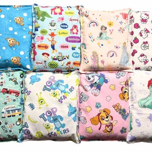 Peut inclure: Un ensemble de huit coussins rectangulaires en tissu arborant divers motifs de personnages de dessins animés, notamment Nemo, Toy Story, des princesses Disney, Hello Kitty, des véhicules de chantier, Monstres et Cie, Pat' Patrouille et Ariel.