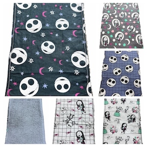 May include: Selection of fabric pieces with different patterns. One has Jack Skellington faces, stars, and moons on a dark background. Another shows Sally, moons, and polka dots. Other fabrics feature Jack and Sally designs.