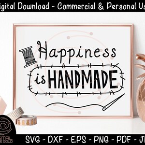 Puede incluir: Un fondo blanco con un gráfico en blanco y negro que dice "Happiness is Handmade". El gráfico incluye un carrete de hilo y una aguja. El gráfico está rodeado por un borde cosido.