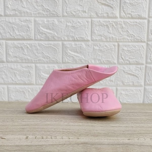 Puede incluir: Un par de zapatillas de cuero rosa. Las zapatillas son suaves y c&oacute;modas, perfectas para relajarse en casa.