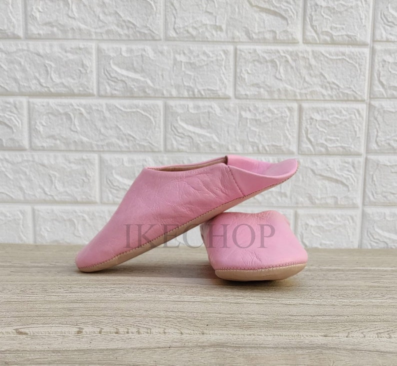 Puede incluir: Un par de zapatillas de cuero rosa. Las zapatillas son suaves y c&oacute;modas, perfectas para relajarse en casa.