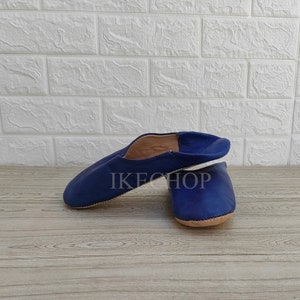 Puede incluir: Un par de zapatillas de cuero azul con un dise&ntilde;o sencillo. Las zapatillas est&aacute;n hechas de cuero suave y tienen un ajuste c&oacute;modo.