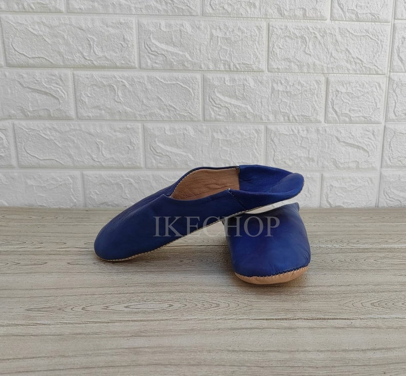 Puede incluir: Un par de zapatillas de cuero azul con un dise&ntilde;o sencillo. Las zapatillas est&aacute;n hechas de cuero suave y tienen un ajuste c&oacute;modo.