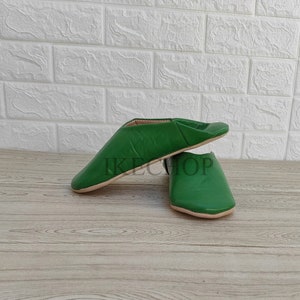 Puede incluir: Un par de zapatillas de cuero verde. Las zapatillas son de punta y tienen un dise&ntilde;o sencillo.
