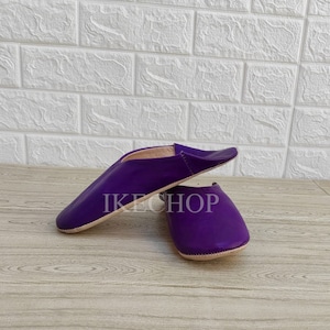 Puede incluir: Un par de zapatillas de cuero morado con punta puntiaguda y suela plana. Las zapatillas est&aacute;n hechas de cuero suave y tienen un ajuste c&oacute;modo.