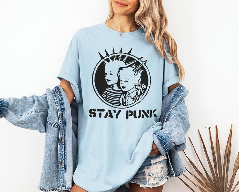 May include: A light blue t-shirt with a black and white graphic of two children with the text "Stay Punk".