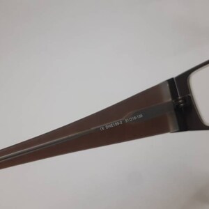 May include: Brown rectangular glasses with a metal frame and clear lenses. The glasses have the text "CE DH2138-2 51□16-138" printed on the frame.