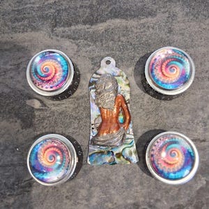 May include: Four guitar control knobs with a colourful spiral design and a mermaid pendant. The knobs have a silver rim and black base. The pendant is made of abalone shell with a mermaid figure.