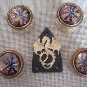 May include: Four gold and copper knobs with snowflake designs and a black guitar pickguard with a gold dragon design.