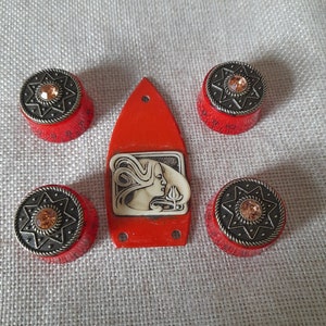 Peut inclure: Ensemble de cinq boutons rouges et noirs avec un motif d'étoile et un seul bouton rouge avec un camée blanc d'un visage de femme. Les boutons sont pour une radio vintage ou un autre appareil électronique.