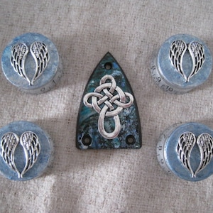 May include: Five small round blue and silver boxes with a Celtic knot design on the top of one box. Each box has a silver angel wing design on the lid.