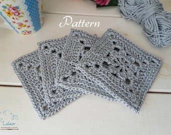 May include: Four crocheted gray square coasters with a delicate floral pattern. The coasters are stacked on top of each other. The word "Pattern" is written in cursive above the coasters.