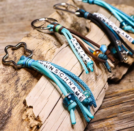Porte-clés personnalisé avec nom, bague de nom, en paracorde avec des  perles dacrylique, divers. Variantes, turquoise-essence-brun-gris -   France