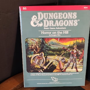 May include: A Dungeons & Dragons Basic Game Adventure module titled Horror on the Hill by Douglas Niles. The cover features a light green background with a central rectangular illustration of armored figures in a forest landscape with a mountain.
