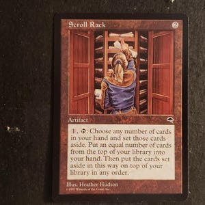 May include: A rectangular Magic: The Gathering trading card titled Scroll Rack. The artwork depicts a figure reaching into a wooden cabinet filled with scrolls. The card features a brown border, the text Artifact, and game rules text in black.