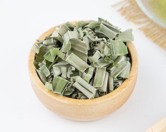 Può includere: Una ciotola di legno piena di citronella secca, un'erba verde chiaro usata in cucina e nelle tisane.