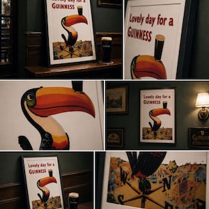 May include: Framed vintage Guinness advertisement featuring a toucan with a pint of Guinness. The poster reads "Lovely day for a Guinness" in red text. A pint of Guinness sits next to the framed poster. The background is a dark green wall.