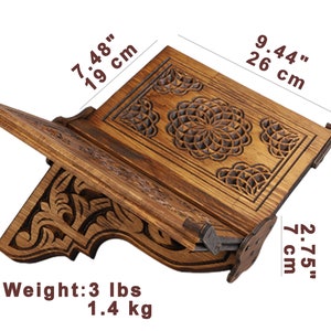 May include: Wooden book stand with intricate carved floral designs. The stand is 9.44 inches (26 cm) wide, 5.11 inches (13 cm) tall, and 7.48 inches (19 cm) deep. It weighs 3 lbs (1.4 kg).