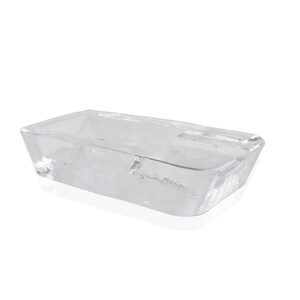 May include: A clear glass rectangular dish with rounded edges. The dish is empty and has a slight reflection on the surface.