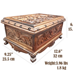 May include: A wooden box with intricate carvings and a hinged lid. The box is 9.25 inches wide, 12.6 inches long, and 6.1 inches high. It weighs 3.96 pounds.