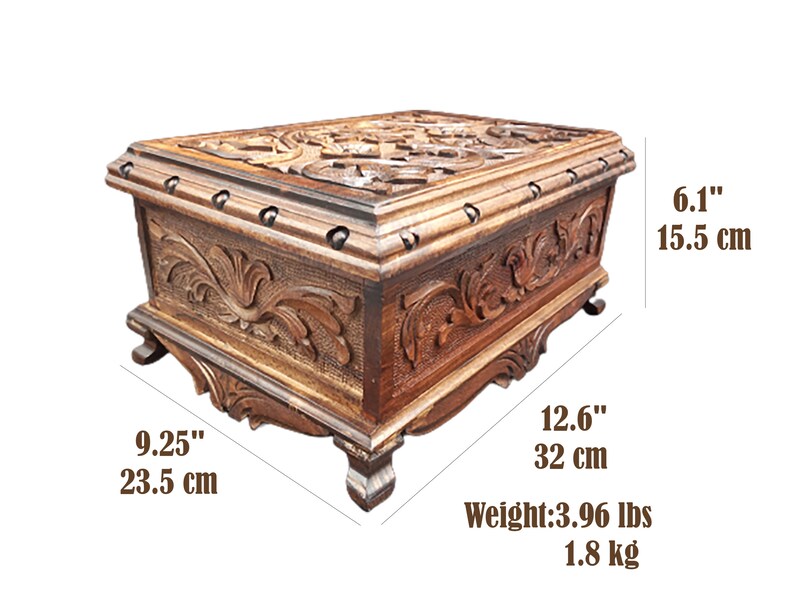 May include: A wooden box with intricate carvings and a hinged lid. The box is 9.25 inches wide, 12.6 inches long, and 6.1 inches high. It weighs 3.96 pounds.