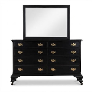 May include: A black wooden dresser featuring eight drawers arranged in two columns, each equipped with ornate brass-toned metal pulls. The dresser is topped with a large, rectangular black-framed mirror and stands on four short, curved legs with casters.