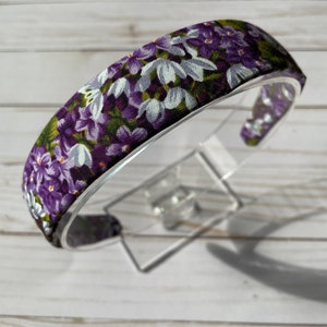 May include: Purple and white floral headband with a wide elastic band.