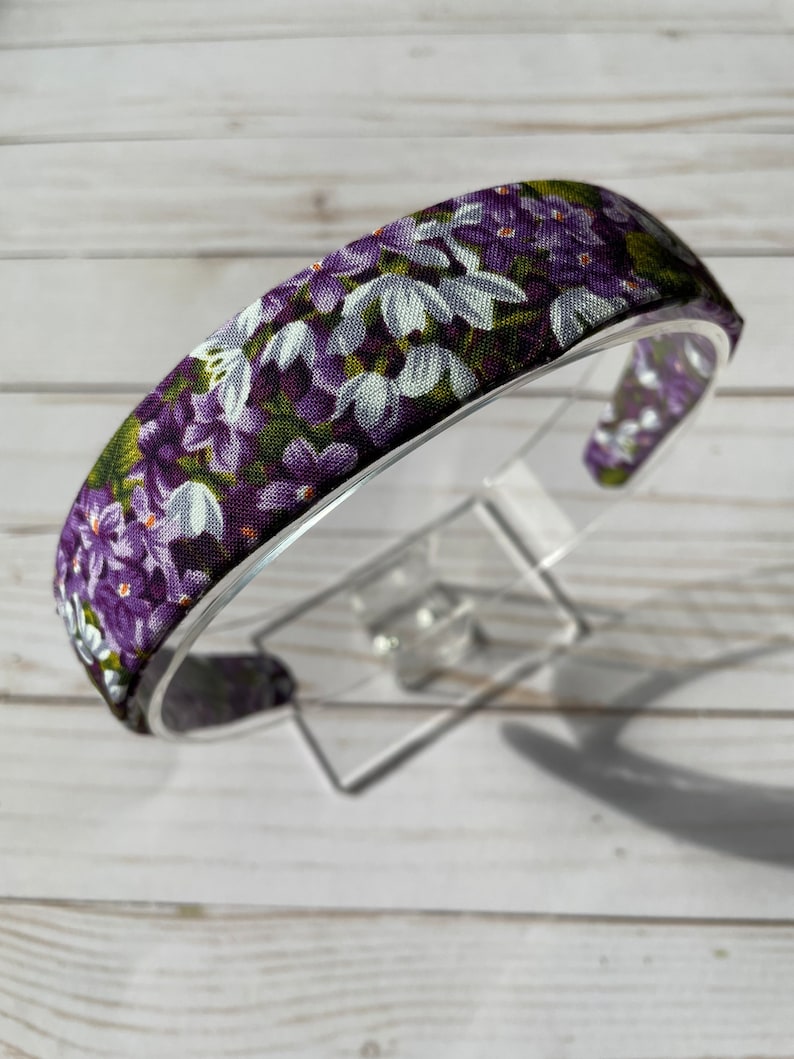 May include: Purple and white floral headband with a wide elastic band.