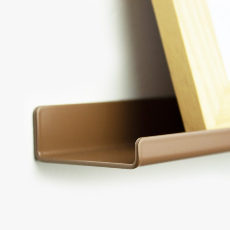 May include: A brown metal shelf with a curved edge. The shelf is mounted to a white wall.