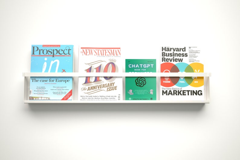 May include: A white shelf with five magazines on it. The magazines are "Prospect", "The New Statesman", "ChatGPT", and "Harvard Business Review". The "Prospect" magazine has the text "The case for Europe" on the cover. The "New Statesman" magazine has the text "The Anniversary Issue" on the cover. The "Harvard Business Review" magazine has the text "The New Basics of Marketing" on the cover.