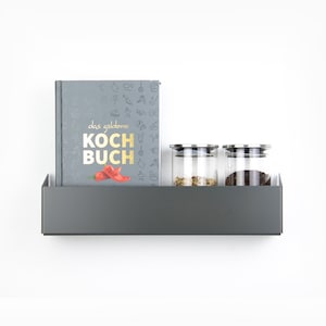 May include: A gray metal shelf with a cookbook titled "das goldene KOCHBUCH" and three glass jars with lids. The cookbook has a red chili pepper illustration on the cover.