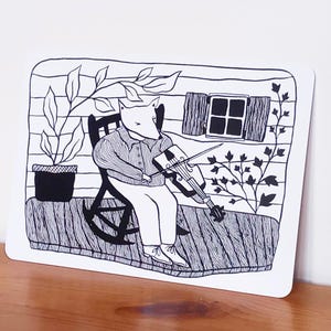 Peut inclure: Illustration en noir et blanc d'un renard jouant du violon, assis dans un rocking-chair sur un porche. Le porche comprend une plante en pot et une fenêtre avec des volets. Le renard porte une chemise boutonnée et un pantalon.