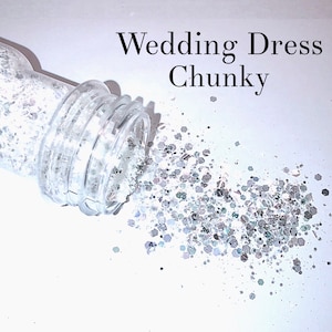 May include: A clear glass jar with a white glitter inside, spilling out onto a white surface. The glitter is chunky and iridescent. The text "Wedding Dress Chunky" is written above the jar.