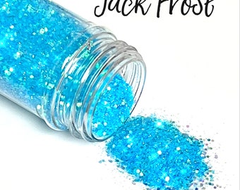 May include: A clear jar of blue glitter with the text "Jack Frost" and "Cocktail Hour Collection" printed on the label. The glitter is spilling out of the jar.