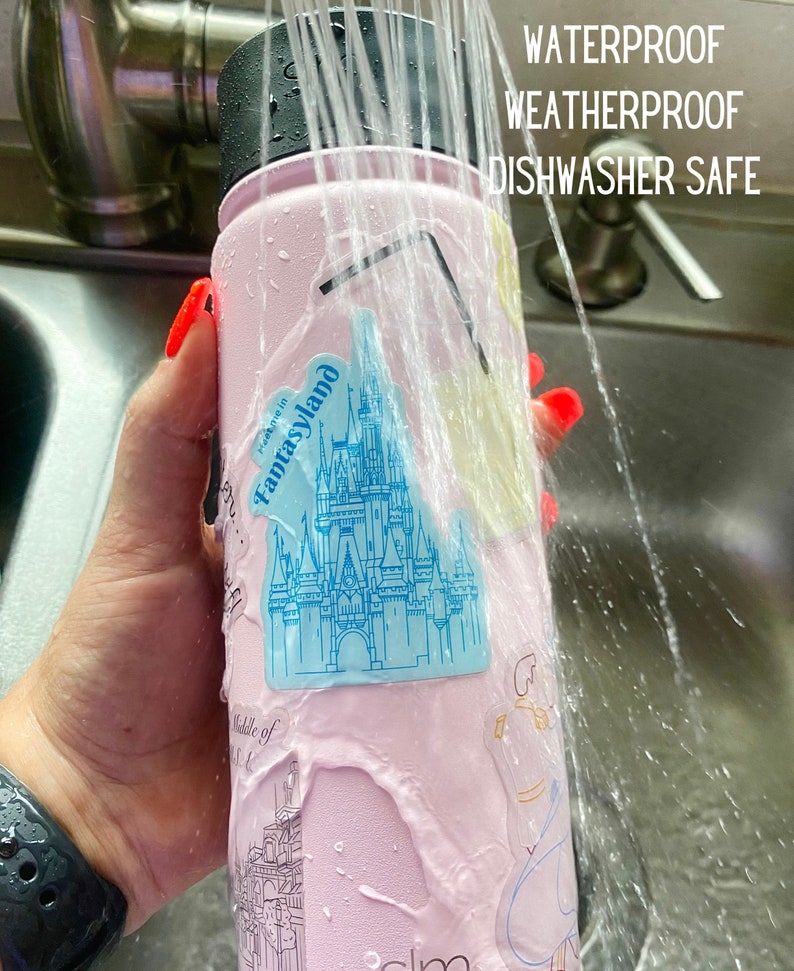 Op de afbeelding: Een roze waterfles met stickers, gewassen met water. De stickers bevatten een blauw kasteel en andere illustraties. De tekst op de fles luidt "WATERPROOF WEATHERPROOF DISHWASHER SAFE".