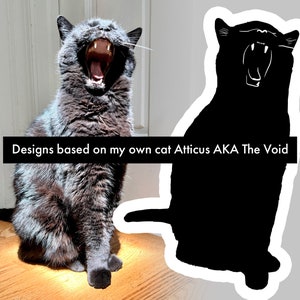 Op de afbeelding: Een grijze kat met groene ogen geeuwt met zijn mond wijd open. De kat zit op een houten vloer. De afbeelding is in twee&euml;n gedeeld, met een zwart silhouet van de kat aan de rechterkant. De tekst "Designs based on my own cat Atticus AKA The Void" staat onderaan de afbeelding.