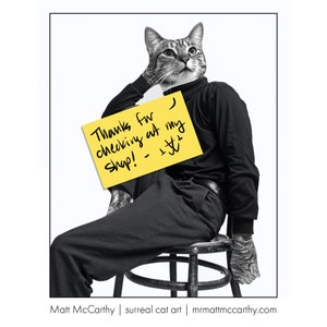 May include: A black and white photo of a cat wearing a black turtleneck and sitting on a stool. The cat is holding a yellow sticky note that says "Thanks for checking at my shop! -  :)"