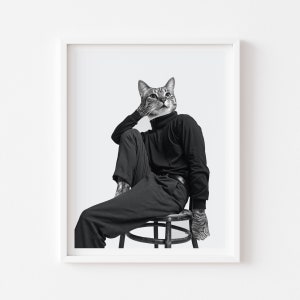 May include: A black and white photograph of a cat wearing a black turtleneck and trousers, sitting on a stool. The cat is looking upwards with a thoughtful expression.
