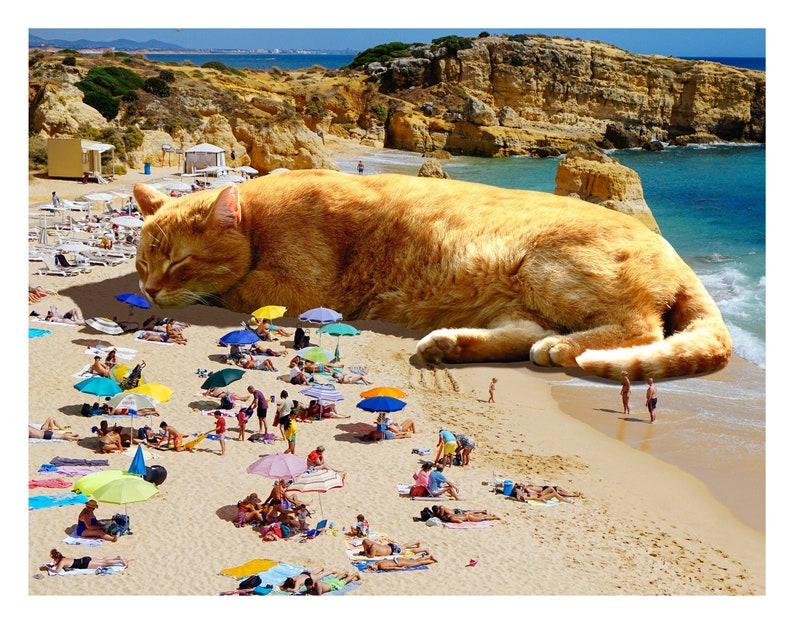 May include: A whimsical image of a giant orange cat sleeping on a sandy beach. People are sunbathing and relaxing under colorful umbrellas. The beach is next to a blue ocean with cliffs in the background.