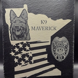May include: Black slate plaque with a white outline of the state of Minnesota. The plaque features a German Shepherd dog, the text "K9 Maverick", and a St. Louis Park Police badge with the text "Officer K9".